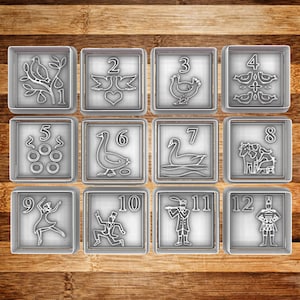 May include: Set of twelve square cookie cutters with numbers and festive designs. Each cutter features a different image, including birds, doves, a hen, swans, and dancers. The cutters are made of silver-colored metal.