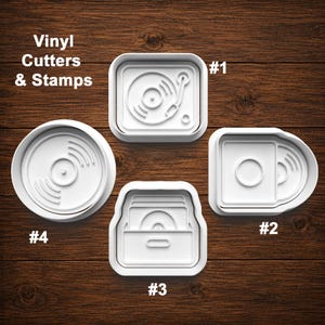 May include: Four white plastic vinyl cutters and stamps labeled #1 through #4. The set includes a record player, a record in a sleeve, a crate of records, and a circular vinyl record. The text Vinyl Cutters & Stamps is visible in the upper left.
