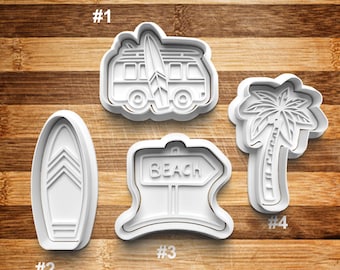 Könnte beinhalten: Satz mit vier weißen Plastik-Ausstechformen in Form eines Surfbretts, einer Palme, eines Vans mit einem Surfbrett auf dem Dach und einem Schild mit der Aufschrift "Beach".