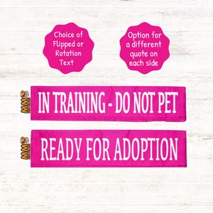 May include: Two pink dog training bands with white text. The top band says "IN TRAINING - DO NOT PET". The bottom band says "READY FOR ADOPTION".