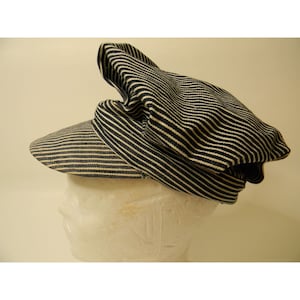 May include: A striped blue and white cotton cap with a wide brim. The cap is folded down on the top.