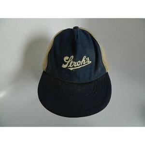 May include: A blue and beige baseball cap with a white mesh back. The front of the cap has the text "Stroh's" in white.
