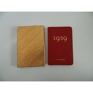May include: A red leather-bound diary with gold lettering that reads "1959". The diary is in a gold patterned box.