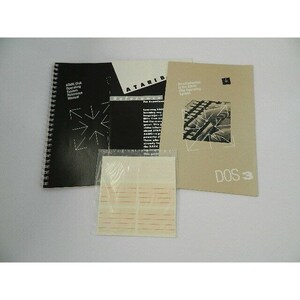 Puede incluir: Tres manuales para el sistema operativo de disco Atari (DOS) versión 3. Los manuales son negros, blancos y beige con texto negro. Los manuales tienen un gráfico de una explosión de estrellas en la portada. El texto en los manuales dice "Manual de referencia del sistema operativo de disco Atari", "Referencia ATARI para programadores" y "Introducción al sistema operativo de disco Atari DOS 3".