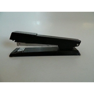 May include: A black metal stapler with a silver staple remover and a clear plastic staple window. The stapler has a long, rectangular base and a lever on the top.