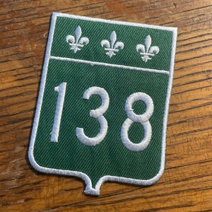 May include: Green and white embroidered patch with the number 138 and three fleurs-de-lis.