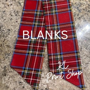 May include: Red plaid fabric with white text that reads "BLANKS". The fabric has a pattern of red, green, yellow, and blue lines. The text "KL Print Shop" is also visible on the fabric.