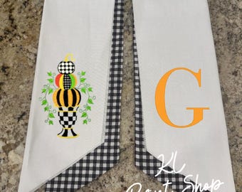 May include: White fabric banner with a black and white checkered trim. One banner features a stacked pumpkin design in orange, green, black, and white. The other banner has an orange letter "G". The text "KL Print Shop" is visible.
