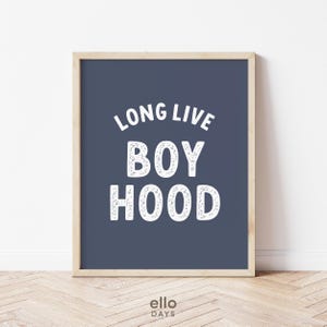 May include: A navy blue framed print with white text that reads "Long Live Boyhood".