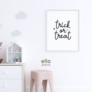 May include: White framed print with black text that reads "trick or treat" with stars on either side of "or". The print is hanging on a white wall with a white dresser and a pink stool in the foreground.