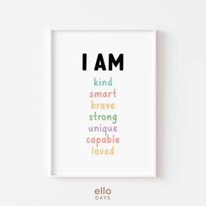 May include: A white framed print with the text "I AM" in black, followed by the words "kind", "smart", "brave", "strong", "unique", "capable", and "loved" in different pastel colours.