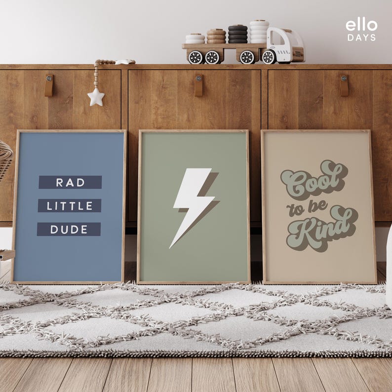 May include: Three framed prints with motivational messages. The first print is blue with the text "RAD LITTLE DUDE". The second print is green with a white lightning bolt. The third print is beige with the text "Cool to be Kind" in a retro font.