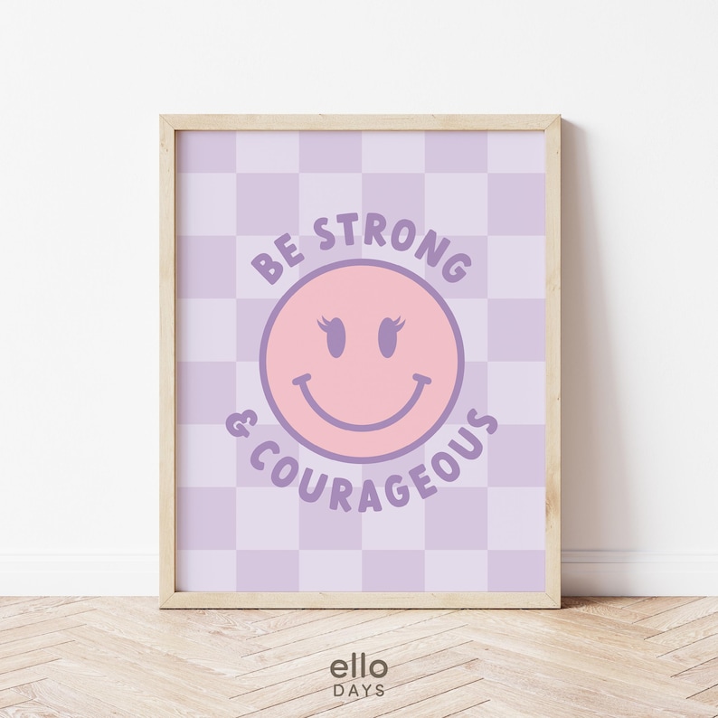 May include: Purple and pink motivational print with a smiling face and the text "Be Strong & Courageous" on a checkered background.