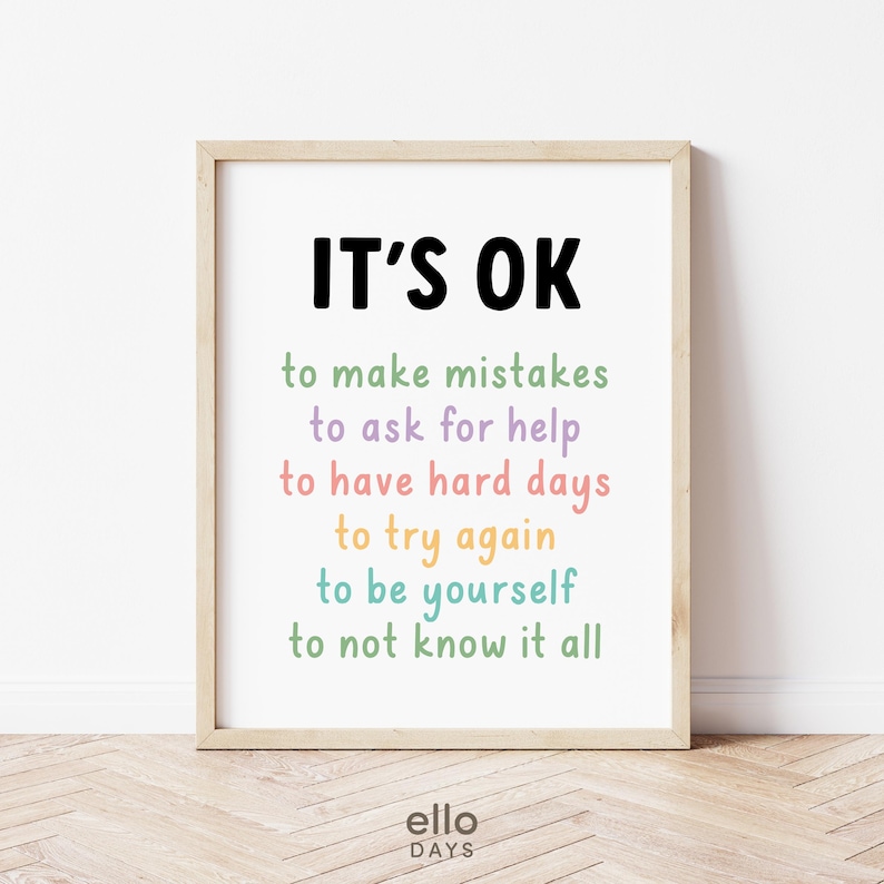 May include: A motivational poster with the text "IT'S OK" in black, followed by a list of phrases in different colours: "to make mistakes", "to ask for help", "to have hard days", "to try again", "to be yourself", and "to not know it all". The poster has a wooden frame and a white background.