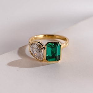 Peut inclure: Une bague en or avec une grande pierre précieuse vert émeraude et une petite pierre précieuse ronde en diamant.