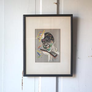 May include: A framed illustration of a person with a black and white face, wearing a hat with the words "2+2=4" written on it. The person is surrounded by colorful pencils and a ruler.
