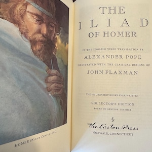 Może przedstawiać: Biały ceramiczny kubek z czarnym uchwytem i napisem "But First, Coffee" czarną, odręczną czcionką. Kubek stoi na białej powierzchni.