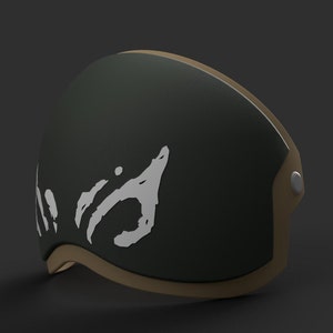 Puede incluir: Un casco verde oscuro con un borde marrón y un diseño gráfico blanco. El diseño gráfico es un diseño abstracto estilizado.