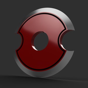 May include: A glossy, red, circular emblem with a silver border and a central hole. The design features two curved cutouts on opposite sides, and a thin black outline. The object is set against a dark gray background.