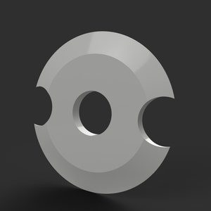 May include: A gray, circular object with a central hole and two curved cutouts on opposite sides. The object has a smooth, metallic appearance and is set against a dark gray background. The design is simple and geometric.