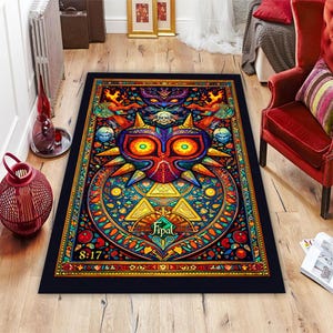 May include: A rectangular area rug with a black border features a colorful, detailed design. The central image is a stylized mask with orange, purple, and yellow hues. The rug has a complex, stained-glass style pattern with the text "Fipal" and "8:17".