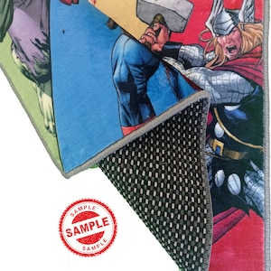 May include: A colorful rug featuring a superhero theme with characters like Captain America, Thor, and Hulk. The rug has a non-slip backing and is labeled "SAMPLE".