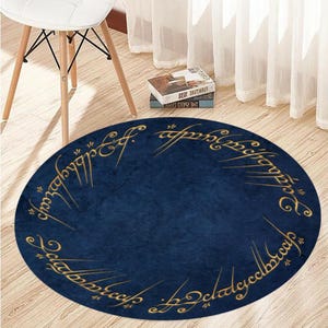 May include: A round blue rug with gold lettering that reads "One Ring to rule them all, One Ring to find them, One Ring to bring them all and in the darkness bind them."