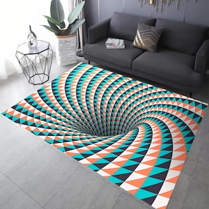 May include: A rectangular rug with a 3D optical illusion design. The rug features a spiraling vortex pattern in teal, orange, black, and white. The rug is placed on a grey tiled floor, with a grey sofa and side table in the background.