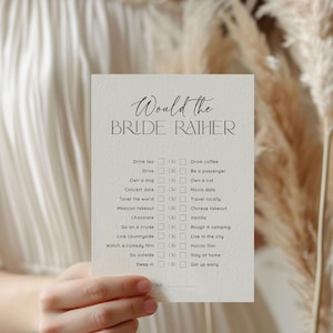 May include: A white card with the text "Would the Bride Rather" in black script. The card has a list of 10 questions with two choices for each question. Each choice has a checkbox next to it.