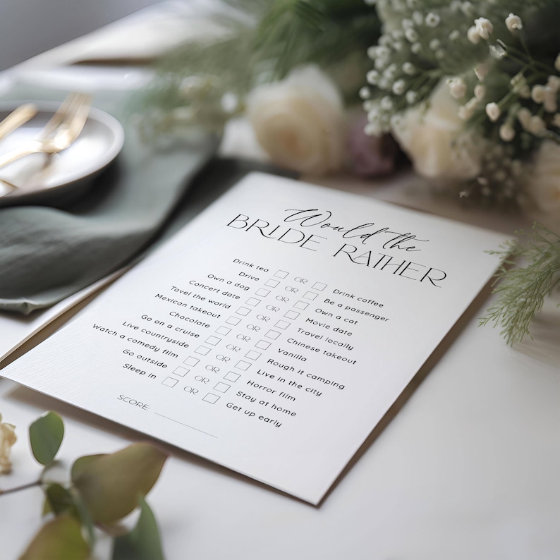 May include: A white card with the text "Would the Bride Rather" in black script. The card features a list of 16 questions with two choices each, such as "Drink tea or Drink coffee" and "Own a dog or Own a cat".  Each choice has a checkbox next to it.