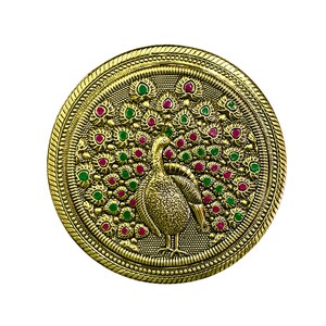 Op de afbeelding: Een ronde, goudkleurige pauwbroche met een gedetailleerd ontwerp. De staartveren van de pauw zijn versierd met rode en groene edelstenen. De broche heeft een sierlijke, getextureerde rand en een gedetailleerde pauwfiguur.