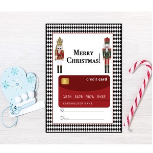 May include: A printable Christmas gift card with a red and white checkered border. The card features two nutcracker illustrations and the text "Merry Christmas!" and "credit card". The card has a space for a cardholder name, a credit card number, and a "To" and "From" section.