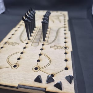 May include: A wooden board game with black pegs and pyramid-shaped pieces. The board has etched designs and holes for the pegs. The game appears to be a strategy or puzzle game, with a focus on spatial reasoning and problem-solving.