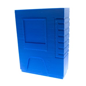 May include: A blue plastic cartridge case with a rectangular opening and a textured surface.