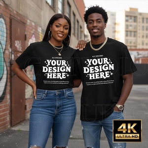 Puede incluir: Dos personas vestidas con camisetas negras con el texto "YOUR DESIGN HERE" en blanco. Las camisetas se combinan con vaqueros azules. La imagen tambi&eacute;n incluye el texto "KC STUDIO" y "Create your visual/graphic using Photoshop, Canva, or other preferred editing software."