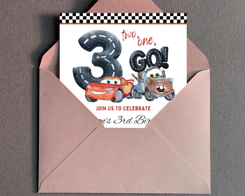 Puede incluir: Una tarjeta de invitaci&oacute;n de cumplea&ntilde;os con el n&uacute;mero 3 dise&ntilde;ado como una carretera, con el texto "two, one, GO!" e im&aacute;genes de coches de dibujos animados. La tarjeta est&aacute; dentro de un sobre rosa, con un dise&ntilde;o de bandera a cuadros en la parte superior.