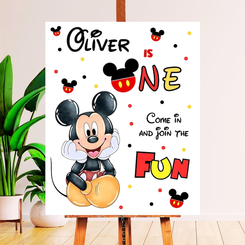 May include: A white sign featuring Mickey Mouse with the text "Oliver is One" and "Come in and join the fun." The design includes red, yellow, and black accents, and Mickey Mouse ears.