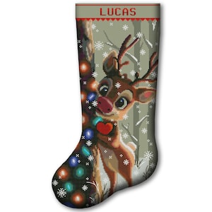May include: Christmas stocking featuring a cartoon reindeer with a red heart and a string of colorful lights. The name "LUCAS" is displayed in red letters at the top. The background shows a snowy forest scene.