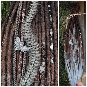 May include: Brown and gray synthetic dreadlocks with silver butterfly and skull charms. The dreadlocks are decorated with copper wire, white string, and black beads.