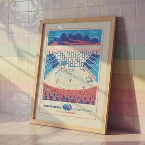 Op de afbeelding: Een ingelijste poster met een roller derby-illustratie. Het kunstwerk toont een roller derby-wedstrijd in een stadion, met spelers, toeschouwers en de tekst "Roller Derby World Cup 2025 Innsbruck Austria". Het kleurenpalet omvat blauw, rood en beige.