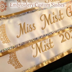 May include: A white ceramic mug with a black handle and the text "But First, Coffee" in a bold, black font. The mug is set against a blurred background, suggesting a cozy setting.