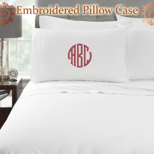 May include: White embroidered pillowcases with a red monogram. The pillowcases are on a white bed with a matching white sheet. The text "Embroidered Pillow Case" is at the top of the image.