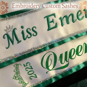 May include: White satin sashes with green embroidered text and accents. The sashes read "Miss Emerald Queen 2025" and "Embroidery Custom Sashes". Each sash has a silver sequin trim and green satin ribbon edges. A crown is embroidered above the word "Miss".