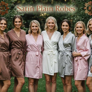 May include: A collection of satin robes in shades of brown, pink, white, and silver, worn by a group of people. The robes feature a wrap-around style with a tie belt. The words "Satin Plain Robes" are visible at the top.
