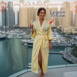 May include: A long, lemon yellow satin robe with a matching tie, personalised with the name "Louise" in black script. The robe is knee-length and has wide sleeves. The text "Long Satin Robes Customize" is at the top.