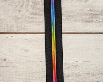May include: Black zipper tape with a rainbow colored stripe down the center.