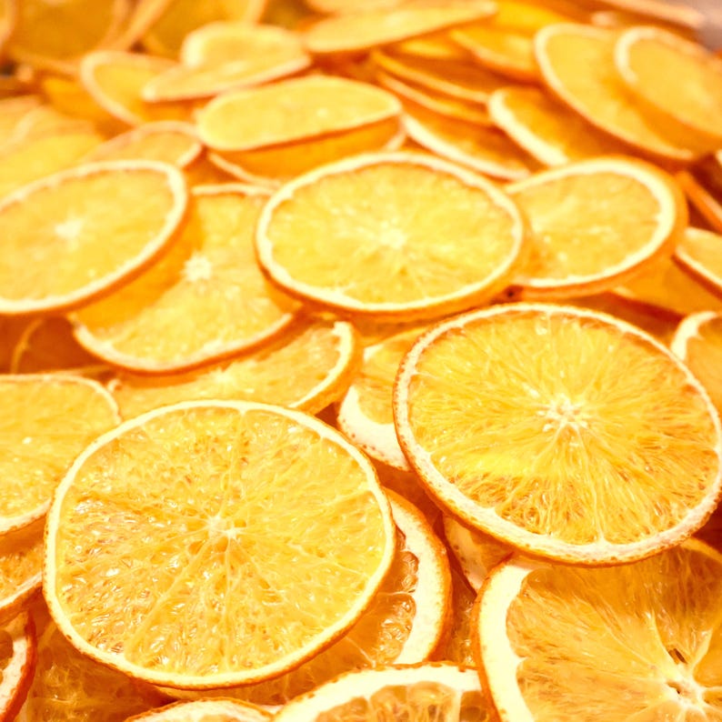 Top view of dried orange slices filling the frame with vibrant color. Perfect dried citrus for handmade crafts, natural decor, or festive displays made from real dried fruits.