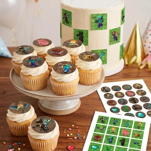 Peut inclure: Un gâteau au glaçage blanc et plusieurs cupcakes surmontés d'images comestibles circulaires représentant des personnages, objets et blocs Minecraft. Deux feuilles d'autocollants carrés et ronds avec des graphismes Minecraft sont posées.