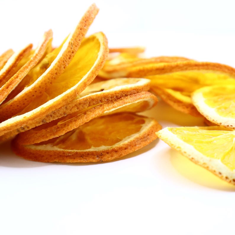 Close-up of handcrafted dried citrus slices showing vibrant texture and authentic orange color. These orange dried slices are excellent as a cocktail garnish, for cake decorating, or as flavorful dry fruit snacks. Made from natural dry oranges, they add a unique citrus aroma to drinks and dishes while being 100% vegan, vegetarian-friendly, and perfect for creative, eco-friendly food styling.