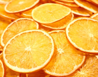 May include: A close-up shot of dried orange slices, displaying a bright yellow-orange hue. The slices are arranged in a slightly overlapping manner, emphasizing their circular form and textured surfaces. The image highlights the natural, organic nature of the dried fruit.